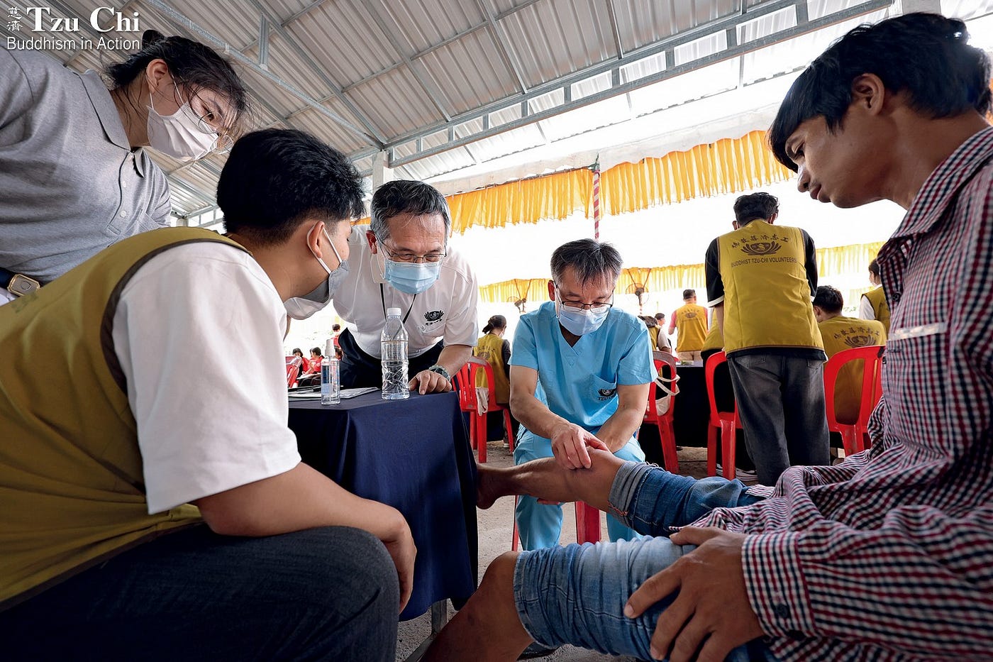 Orthopedic doctor Hung Shuo-suei (洪碩穗, middle) and Taipei Tzu Chi Hospital Deputy Superin­tendent Chang Heng-chia (張恒嘉, second from left) conduct a joint consultation at the internal medicine department during the free clinic. Cross-department collaboration boosts the clinic’s effectiveness.