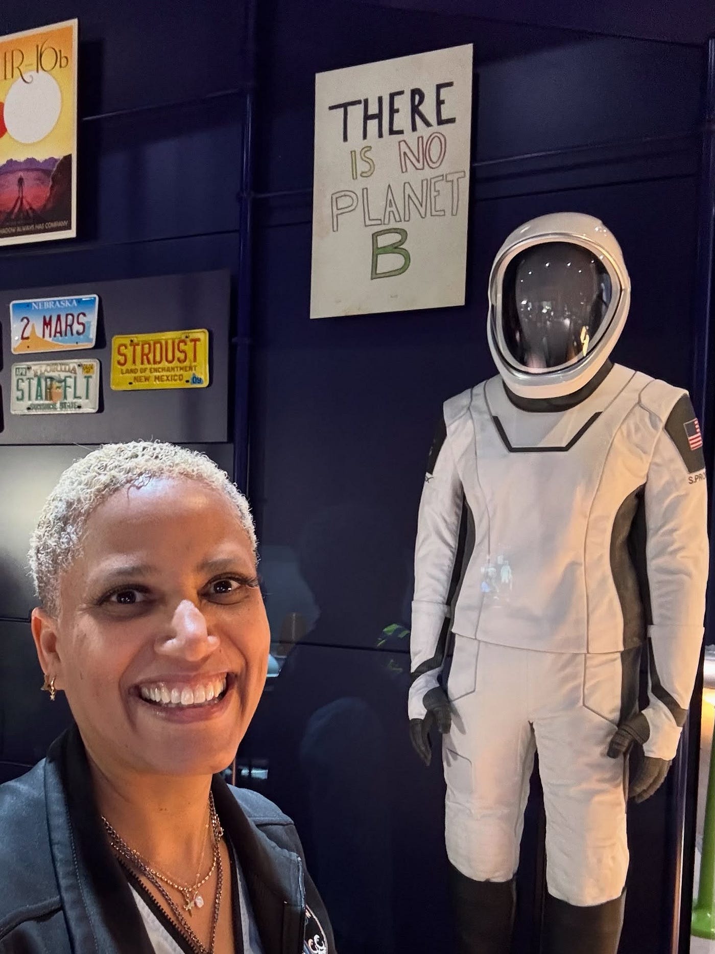 “THERE IS NO PLANET B” — Dr. Sian Proctor in front of her custom SpaceX Launch-and-Entry Spacesuit, on display at the Smithsonian National Air & Space Museum’s new Futures in Space exhibition (photo: S. Proctor)
