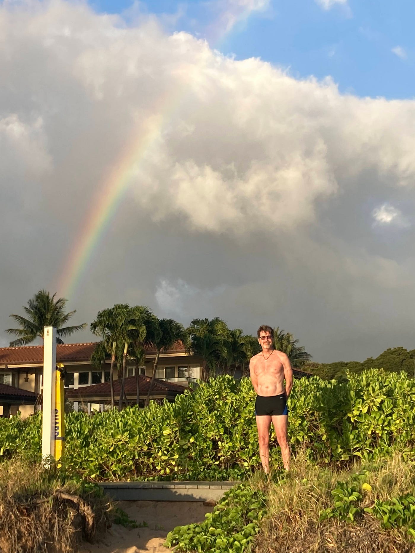 A rainbow amidst dark clouds in Hollywood and one behind Eddie on the island of Maui, HI | Photos by Joe Guay