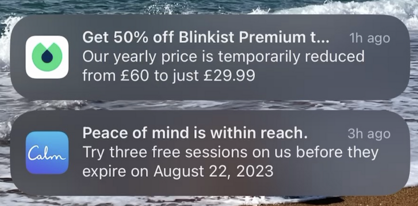 Blinkist からの割引通知と Calm からの無料セッション プッシュの 2 つの通知が表示された iOS ロック画面のスクリーンショット