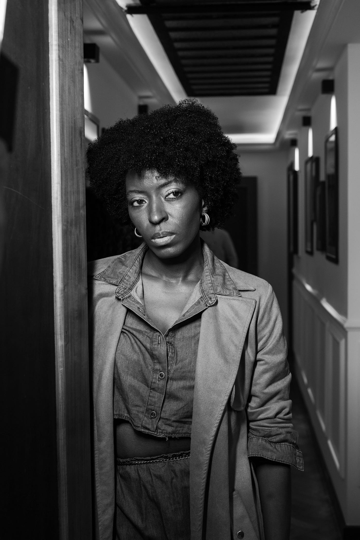 Black woman standing in doorway with thoughtful look | Photo by Jonathan Goncalves via Pexels