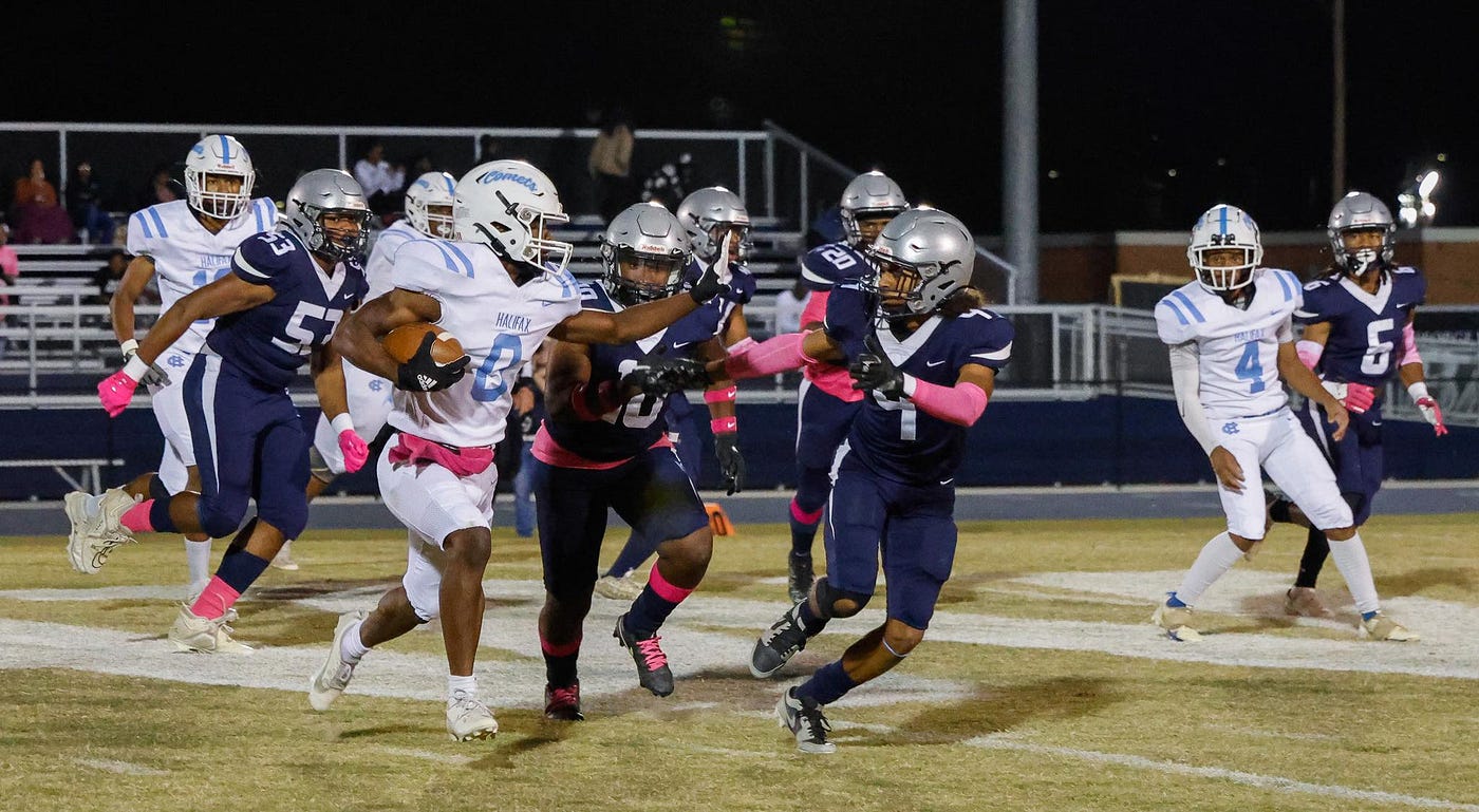 Halifax County senior Joshua Easley (0) cuts around the right side while being pursued by senior Avante Fitzgerald (10) and junior Antonio Matos Friday evening. PHOTO: Brian Cendejas/Special to River City Sports.