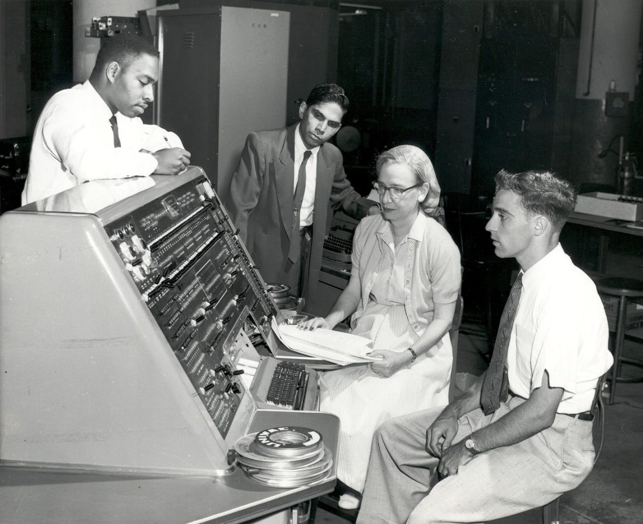 The operator’s console of a Univac I computer with four computer programmers (1957). From left to right, Donald Cropper, K. C. Krishnan, Grace Murray Hopper, and Norman Rothberg. (Courtesy of the Computer History Museum)