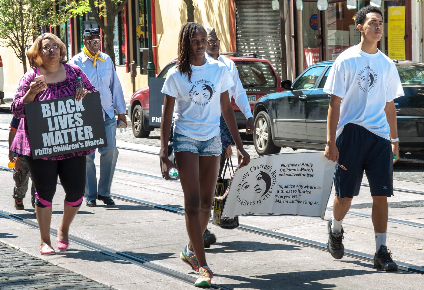 Community members march to the Festival with banners and signs. Photographed by Tieshka Smith at the 10th annual Philadelphia Juneteenth Festival in Germantown, June 18, 2016. This image is protected by copyright.