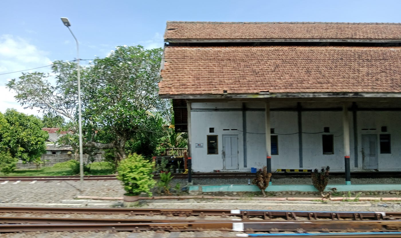 A parked train and a building at Kutoarjo station.