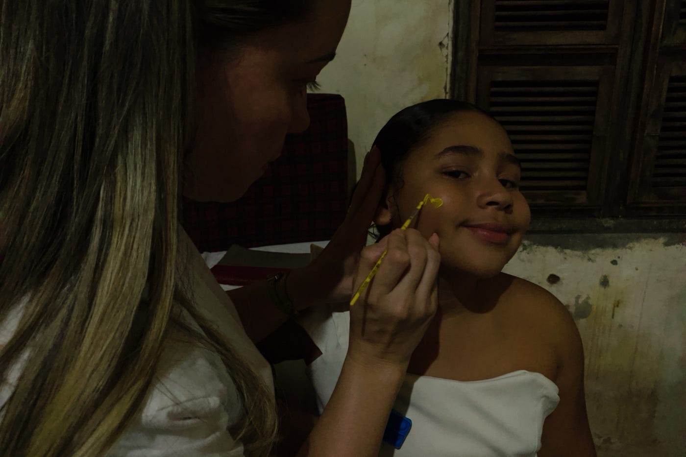 Evangelista da Igreja Bíblica Adonay pintando o rosto de uma criança durante o projeto em Caninhas, Aracoiaba-CE. | Foto: Melissa Queiroz
