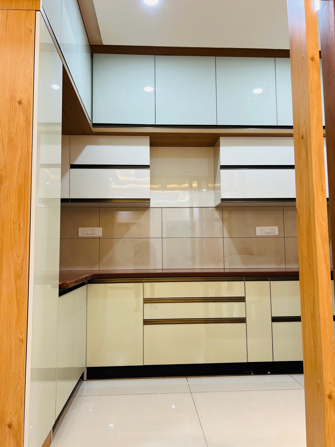 A thoughtfully designed modular kitchen featuring glossy finishes, warm wooden accents, premium countertops, and smart storage solutions — crafted to make everyday cooking effortless and beautiful.