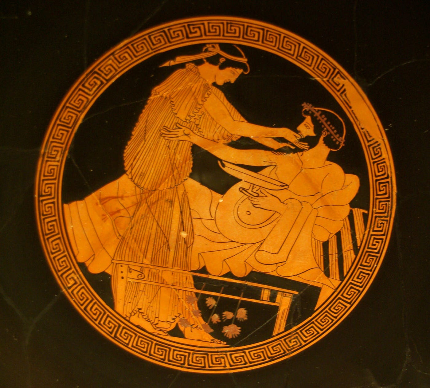 A scene from the interior bowl of a red-figure kylix or stemmed drinking cup (490–480 BCE) depicting a symposiast and hetaira — high-class prostitute. (Museum of Fine Arts, Boston)