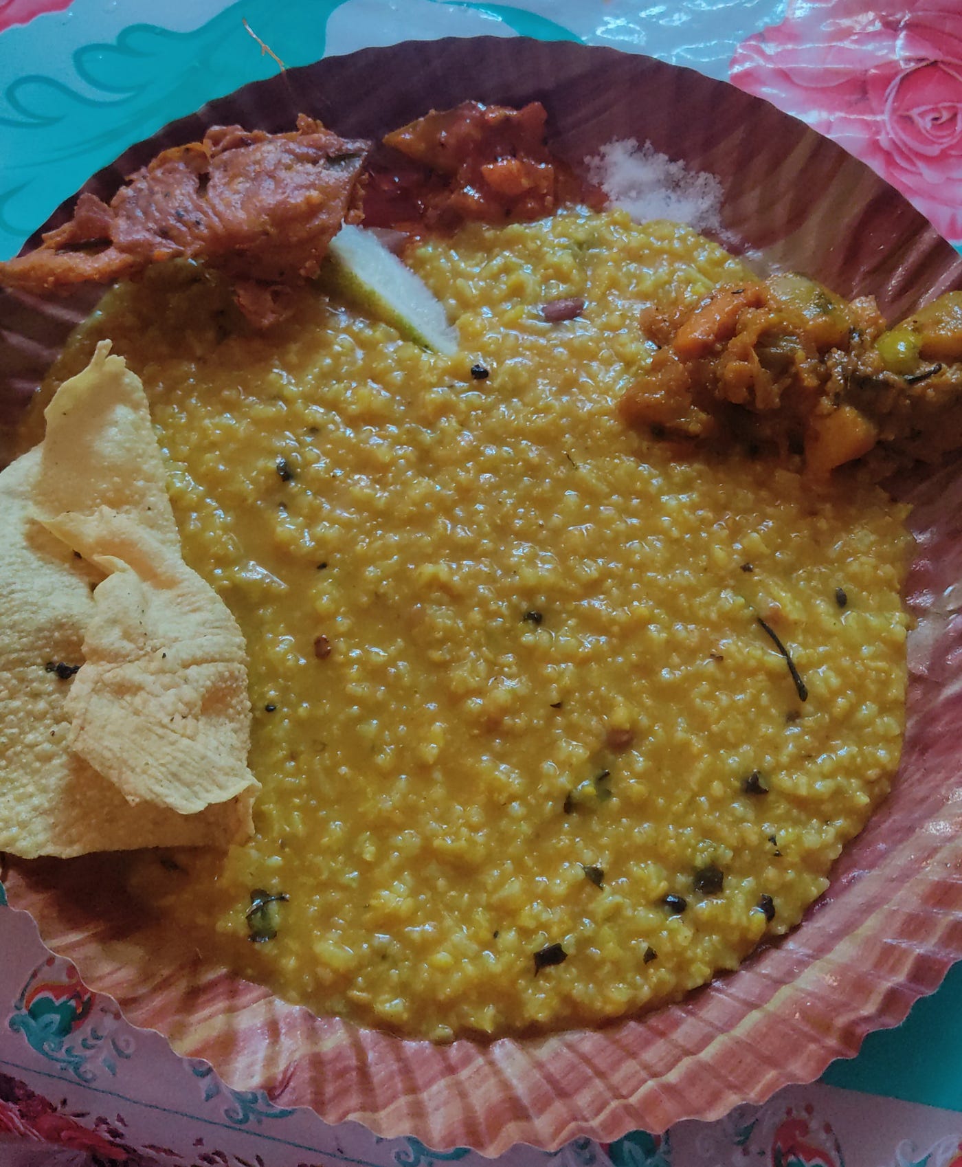 A thin watery khichuri (one pot rice and lentils) was common during famine due to shortage of rice and lentils. Today we like to eat it with multiple side dishes (papadum, pumpkin fritters, mixed vegetables, Indian pickles etc.) earlier in the days of famine, a bowl of simple khichuri was the sole meal for survival for many. Photo by the author.