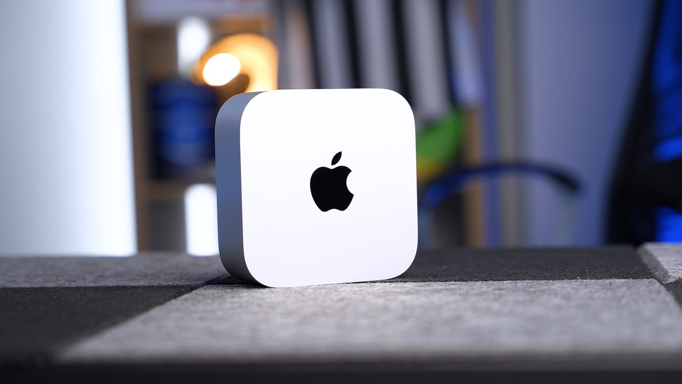 تم وضع جهاز Mac mini M4 على مكتب من القماش الفاتح الفاتح والغامق.