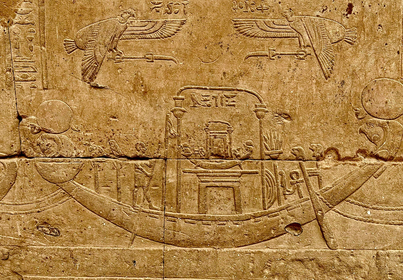Left: One of the pair of Horus statues that guard the entrance. Right: Bas-relief of a barque carying the Ark of Horus. Photos: David A. Laws