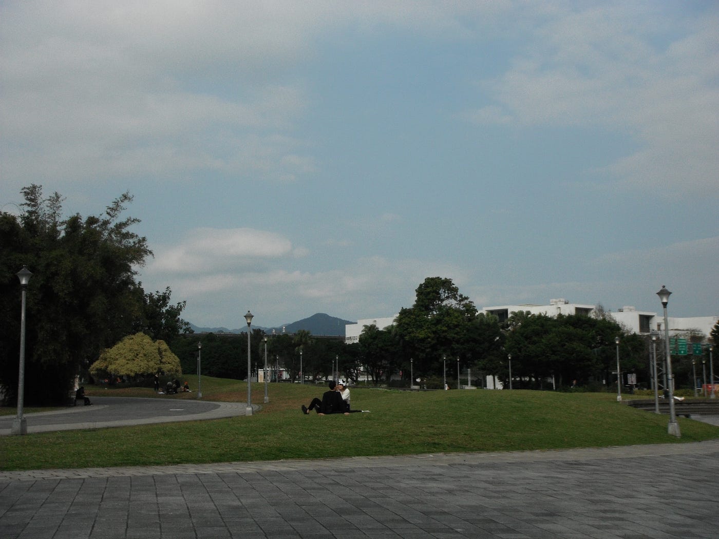 圓山花博公園向北美館方向望⋯⋯情侶愜意又隨意地坐在草地上約會,真可愛⋯⋯