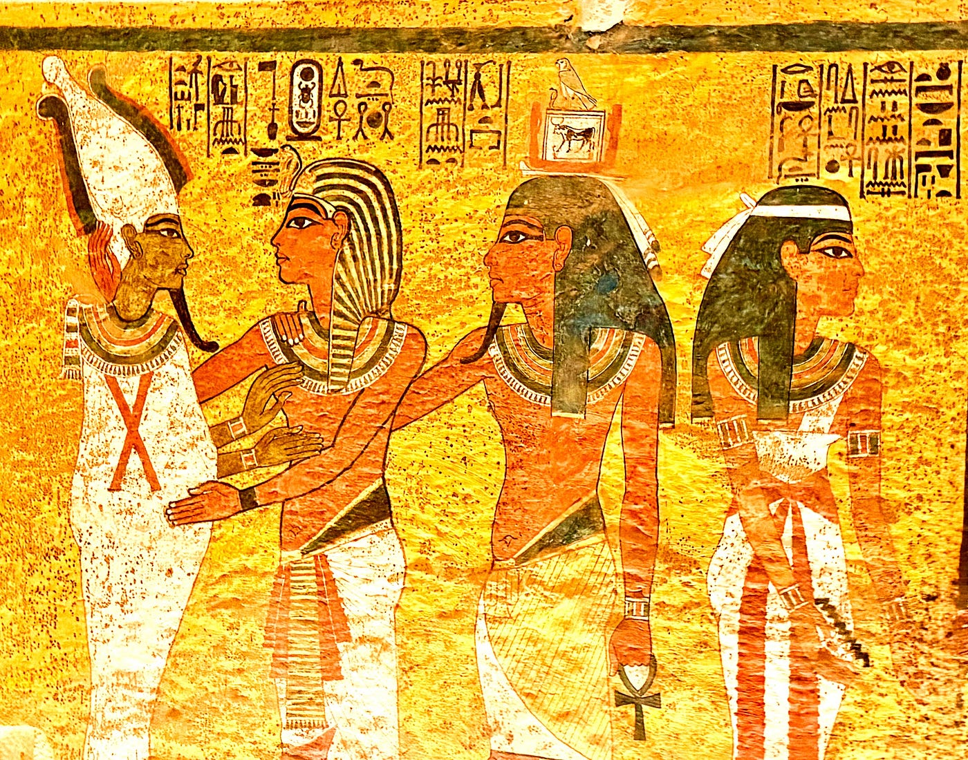 Left: Tutankhamen’s mummy in tomb # KV 62 . Right: Mural of Tutankhamen being embraced by Osiris. Photos: David A. Laws