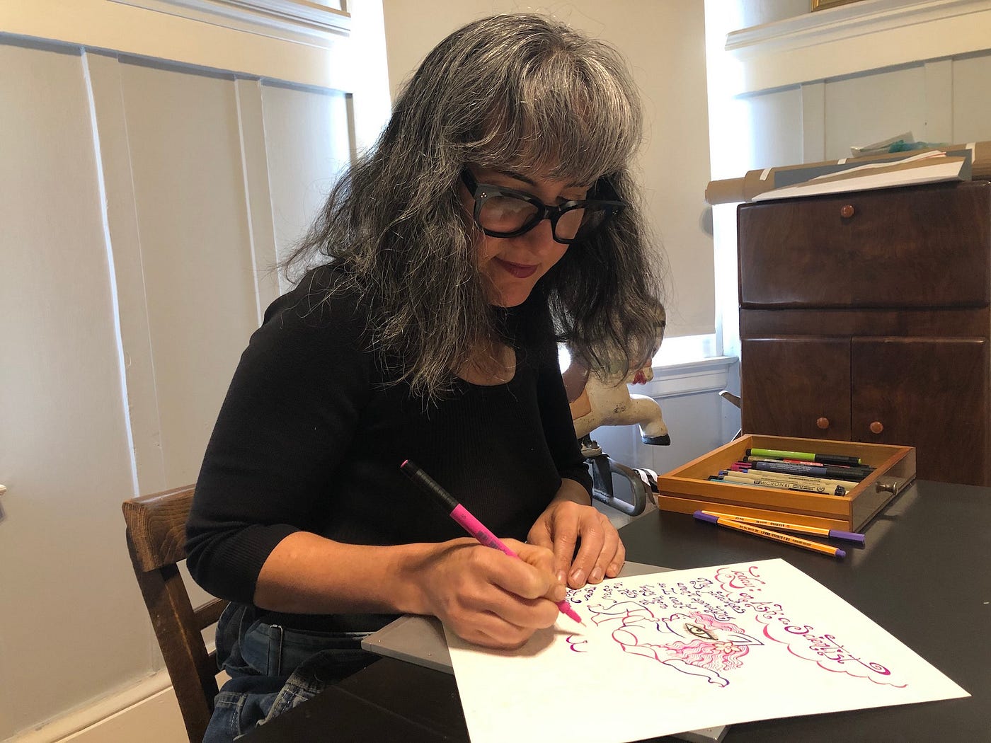 Dorian Katz sitting at a table, drawing with markers.