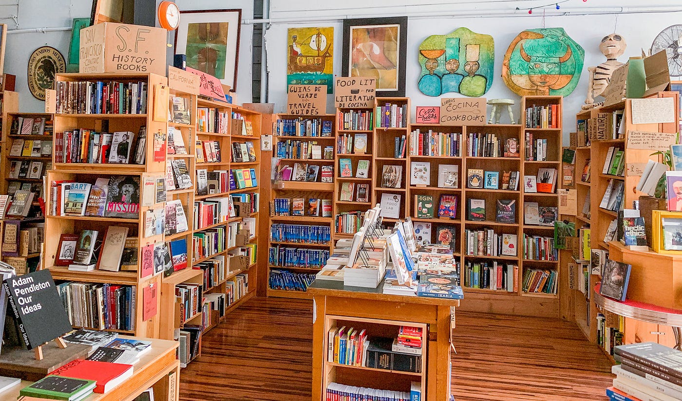 Inside a bookshop with light wooden bookcases and ample natural lighting.