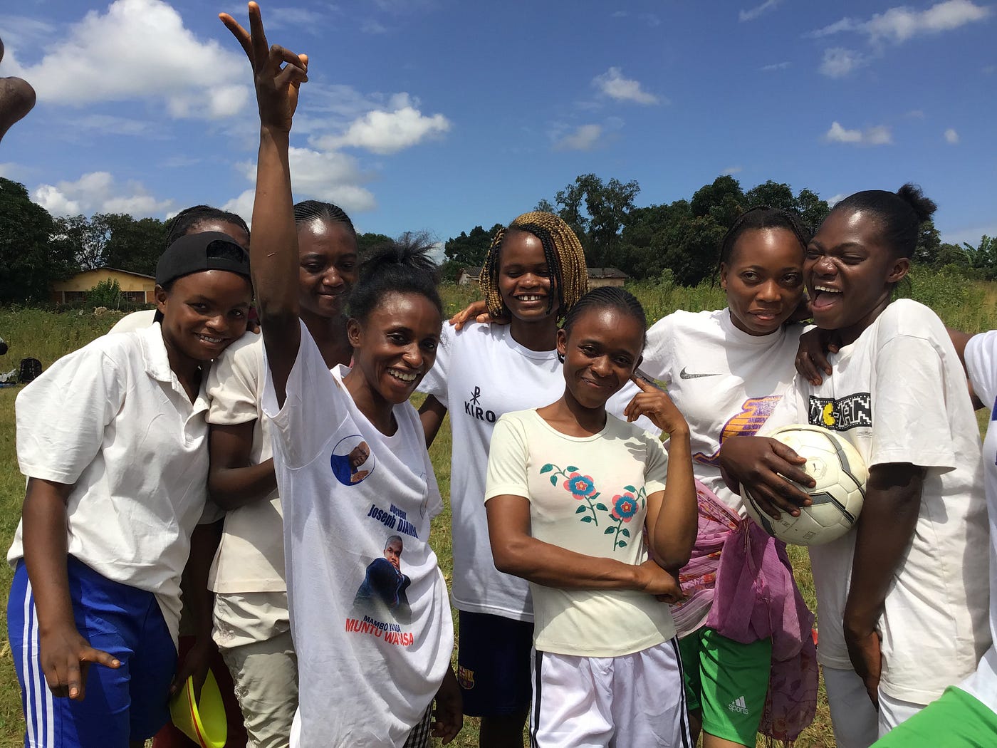 A group of participants in white shirts celebrating.