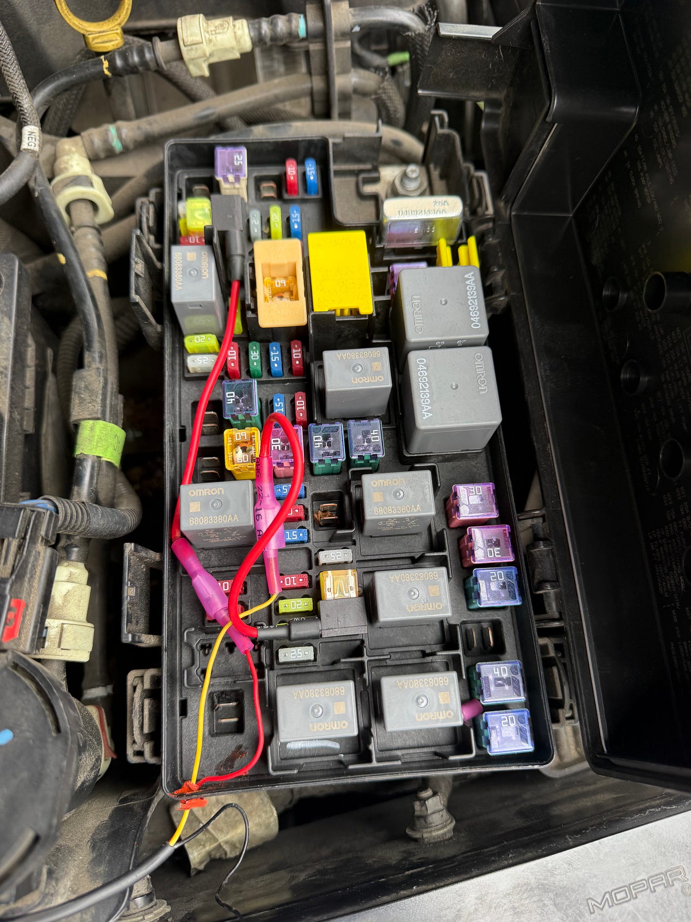 Top-down view of the engine bay fuse box with the taps installed