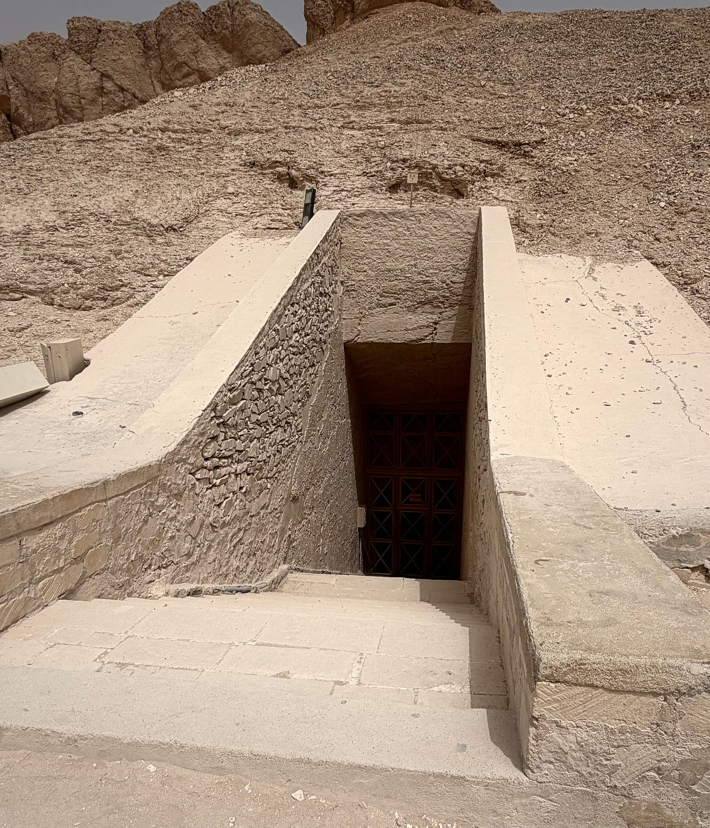 Left: The pyramid-shaped peak of Al-Qurn overlooks the valley. Right: A typical (modern) tomb entry. Photo: David A. Laws
