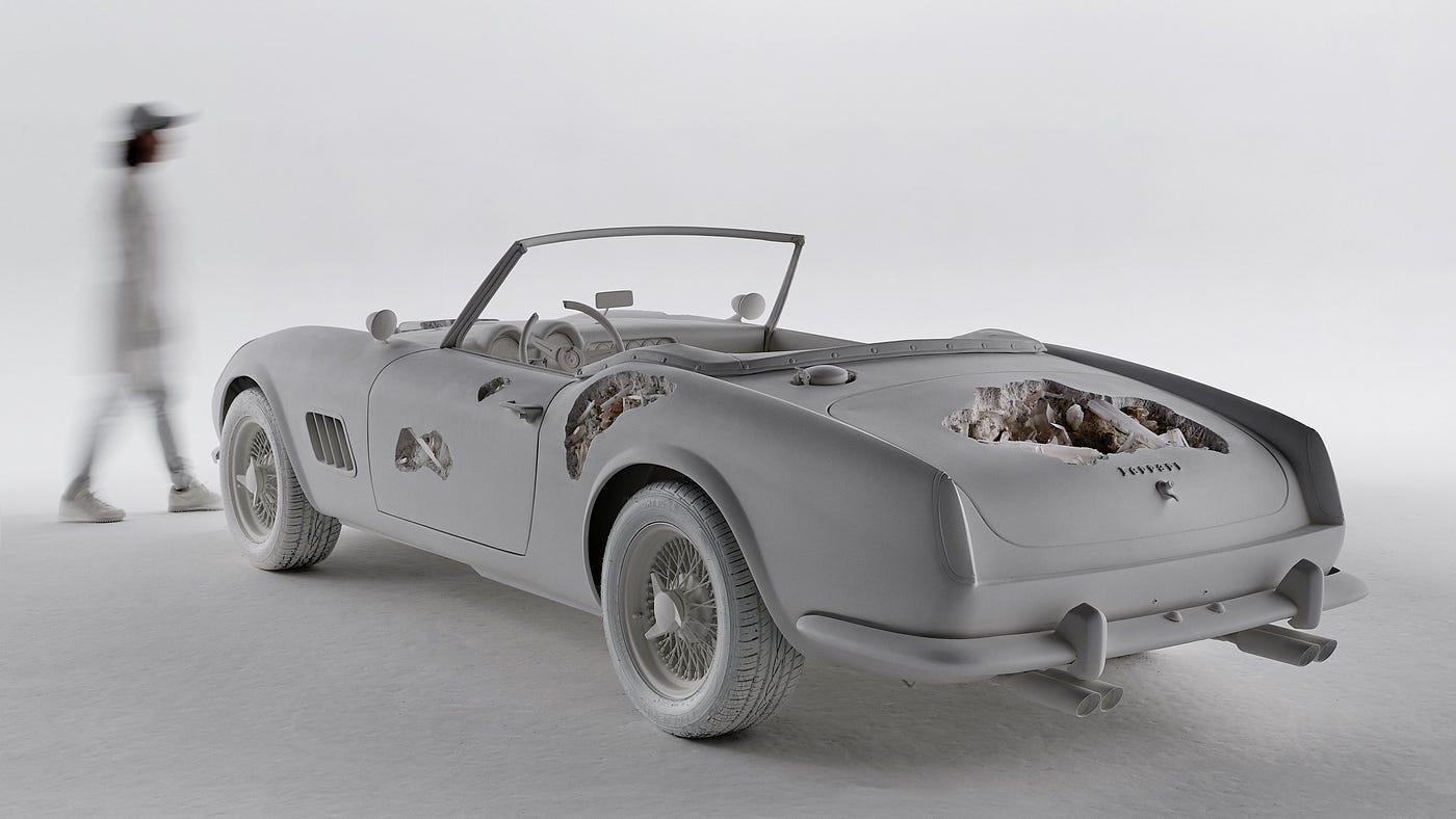 A recreation of a 1961 Ferrari convertible — with a twist. Portions of the car are cratered out or have gashes, both on its exterior and within the car’s upholstery and dashboard. Beautiful mineral crystals emerge from those damaged cavities.