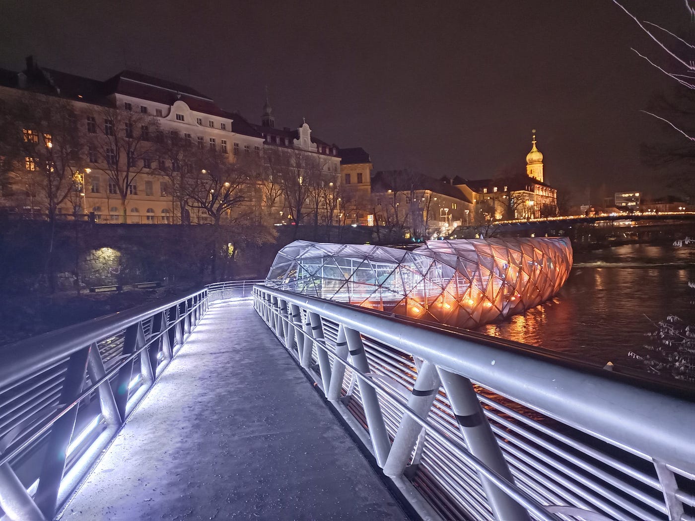 The Murinsel illuminated in colorful lights in Graz, Austria. December 2025. Photo by author