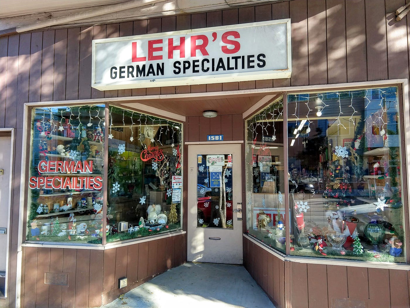 The brown-plank exterior of Lehr’s German Specialties. The windows are decorated with snowflakes and Christmas lights.