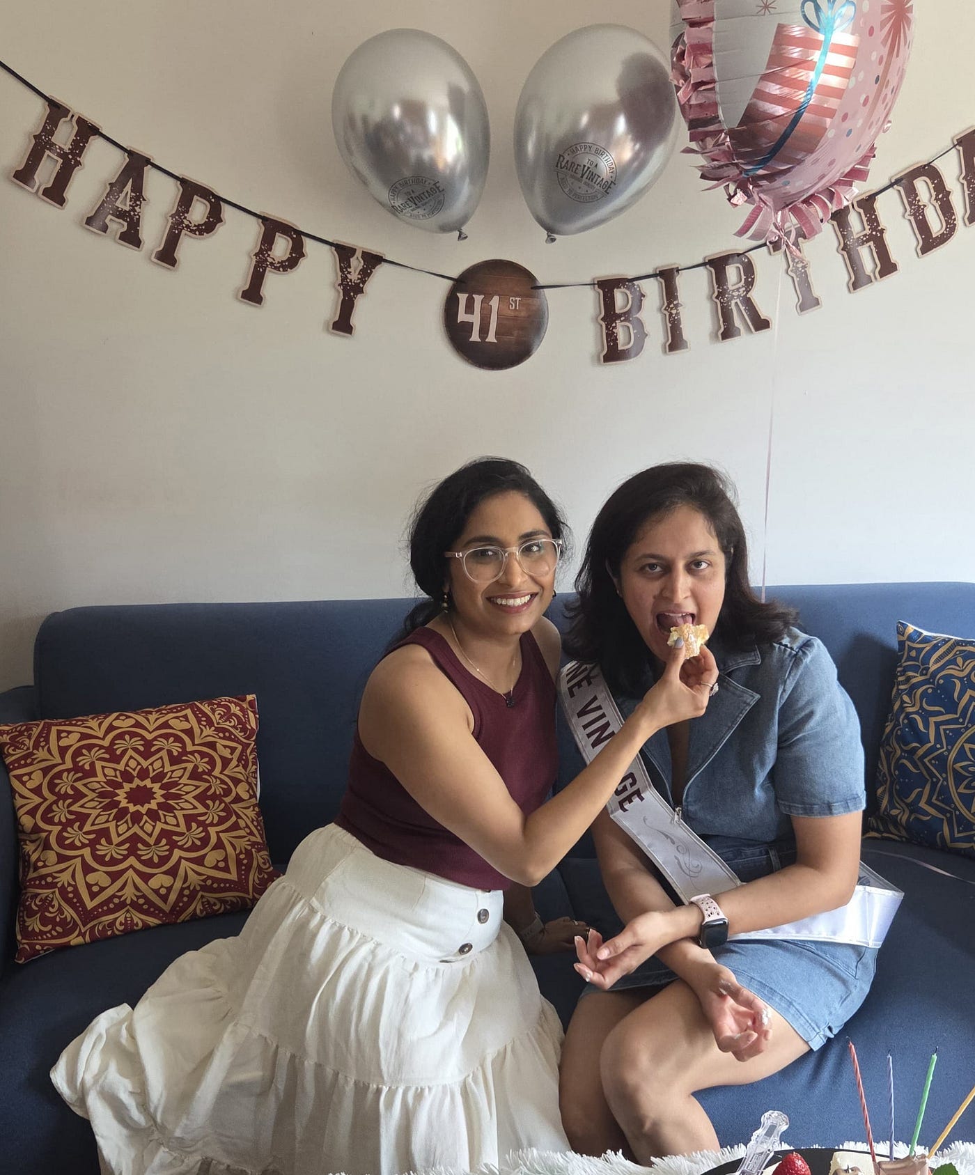 The surprise guest feeding cake to the birthday girl