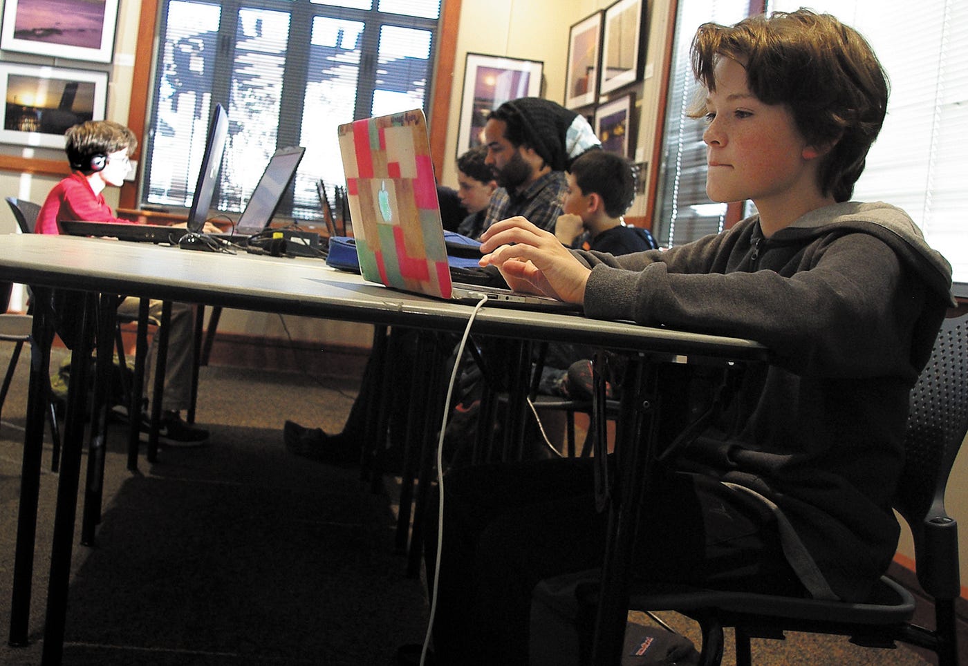 Monty Brown (front right), 11, works on his model of the Golden Gate Bridge during Tiburon CoderDojo, held Fridays after school at the Belvedere-Tiburon Library and led by Ivan Silva (center), the Web services and reference librarian. (Hannah Beausang/ The Ark)