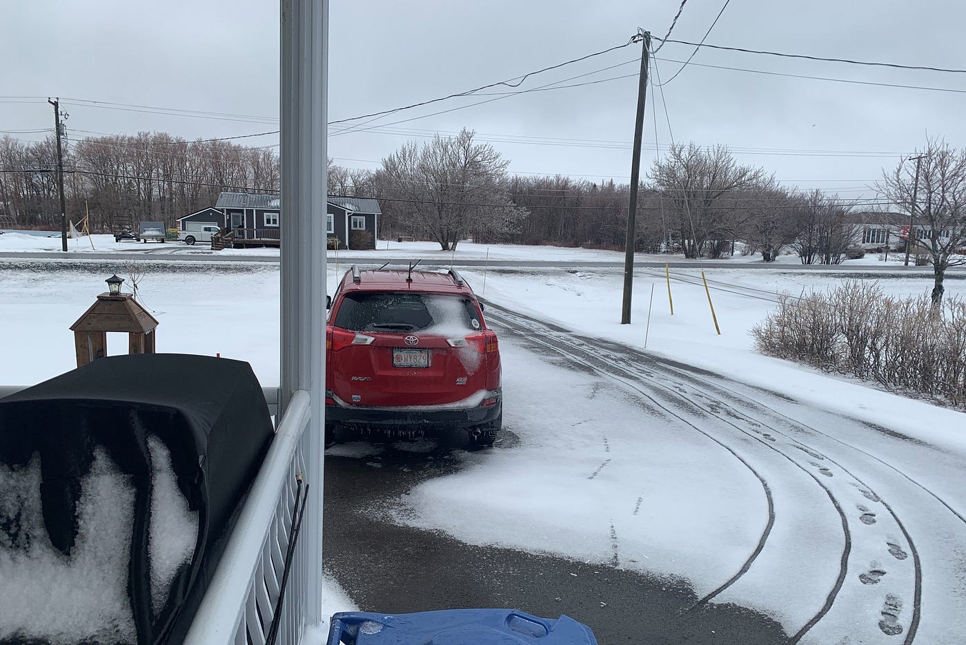 저자의 차도가 눈보라로 뒤덮인 모습, 중앙 왼쪽에 빨간색 SUV가 있고 왼쪽 전경에 바비큐가 있습니다.<BR>