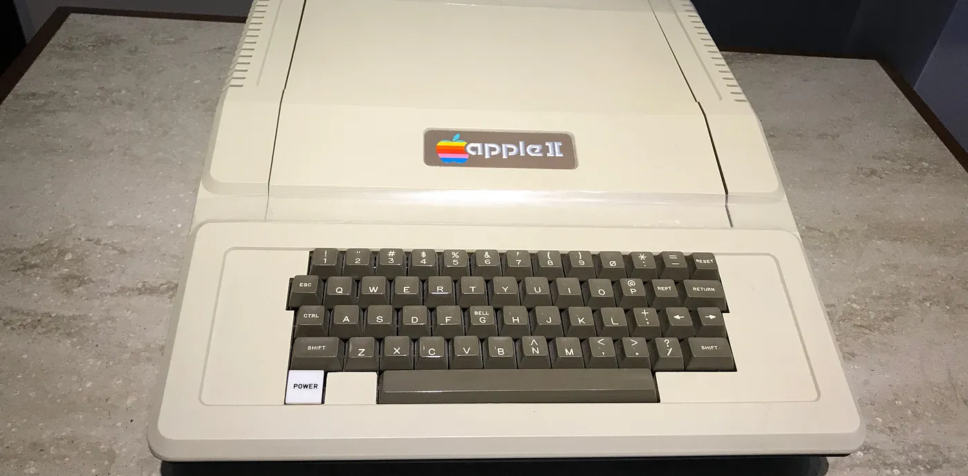 An old Apple II computer sits on a table at a computer museum.