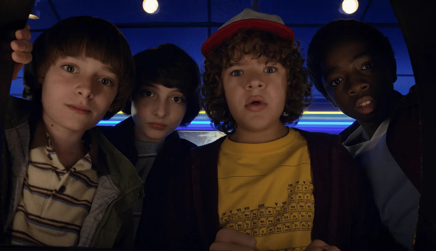 L to R: Will Byers (Noah Schnapp), Mike Wheeler (Finn Wolfhard), Dustin Henderson (Gaten Matarazzo), and Lucas Sinclair (Caleb McLaughlin) all looking into the camera in season 1 of Stranger Things.