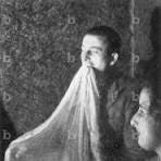 Historical séance photography showing ectoplasm emerging from the medium’s mouth under controlled low‑light conditions, 1890–1935