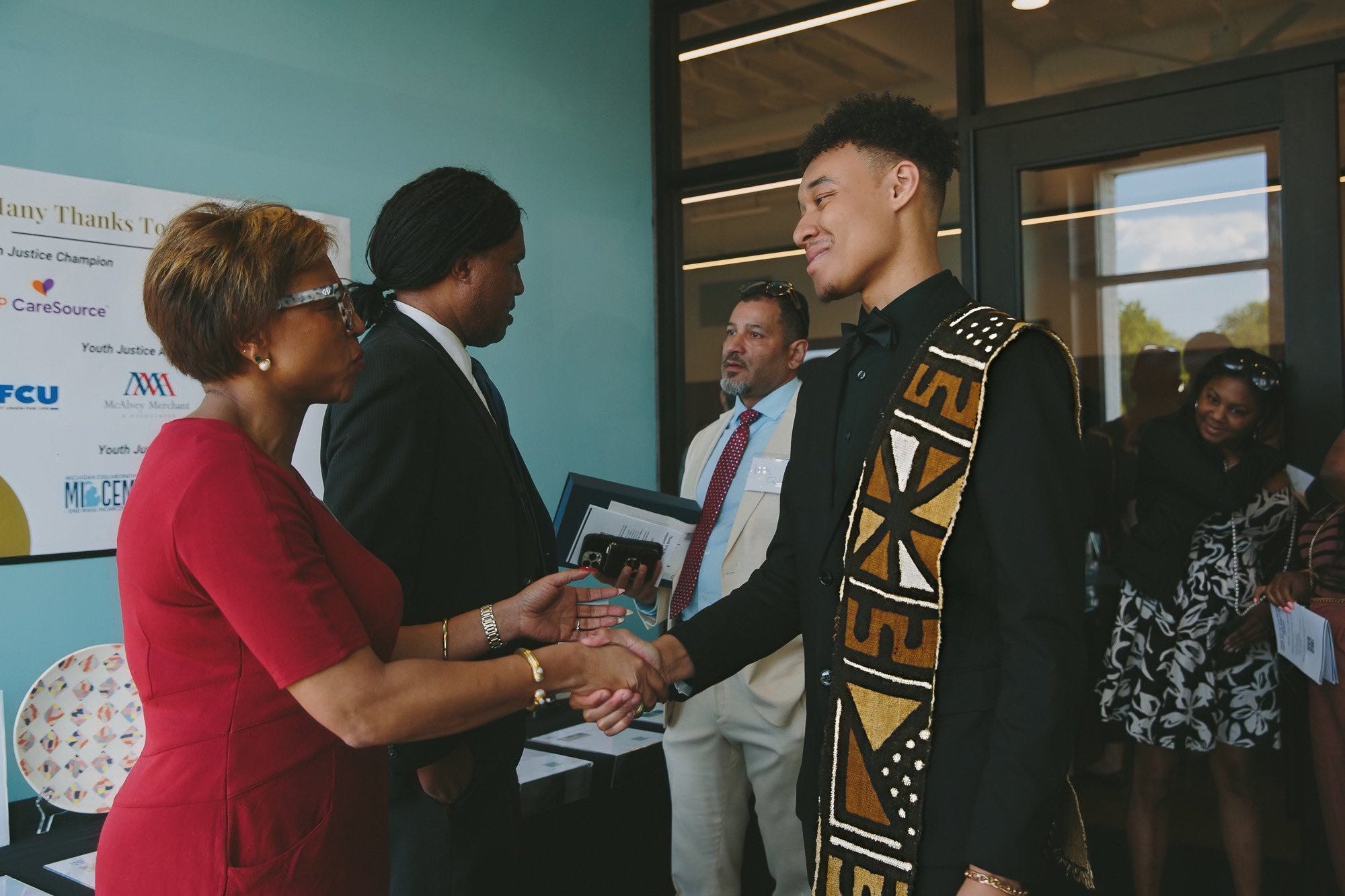 Cayden Brown handshake with Senator Sylvia Santana as they recieve advoacay awards from the Michigan Center for Youth Justice