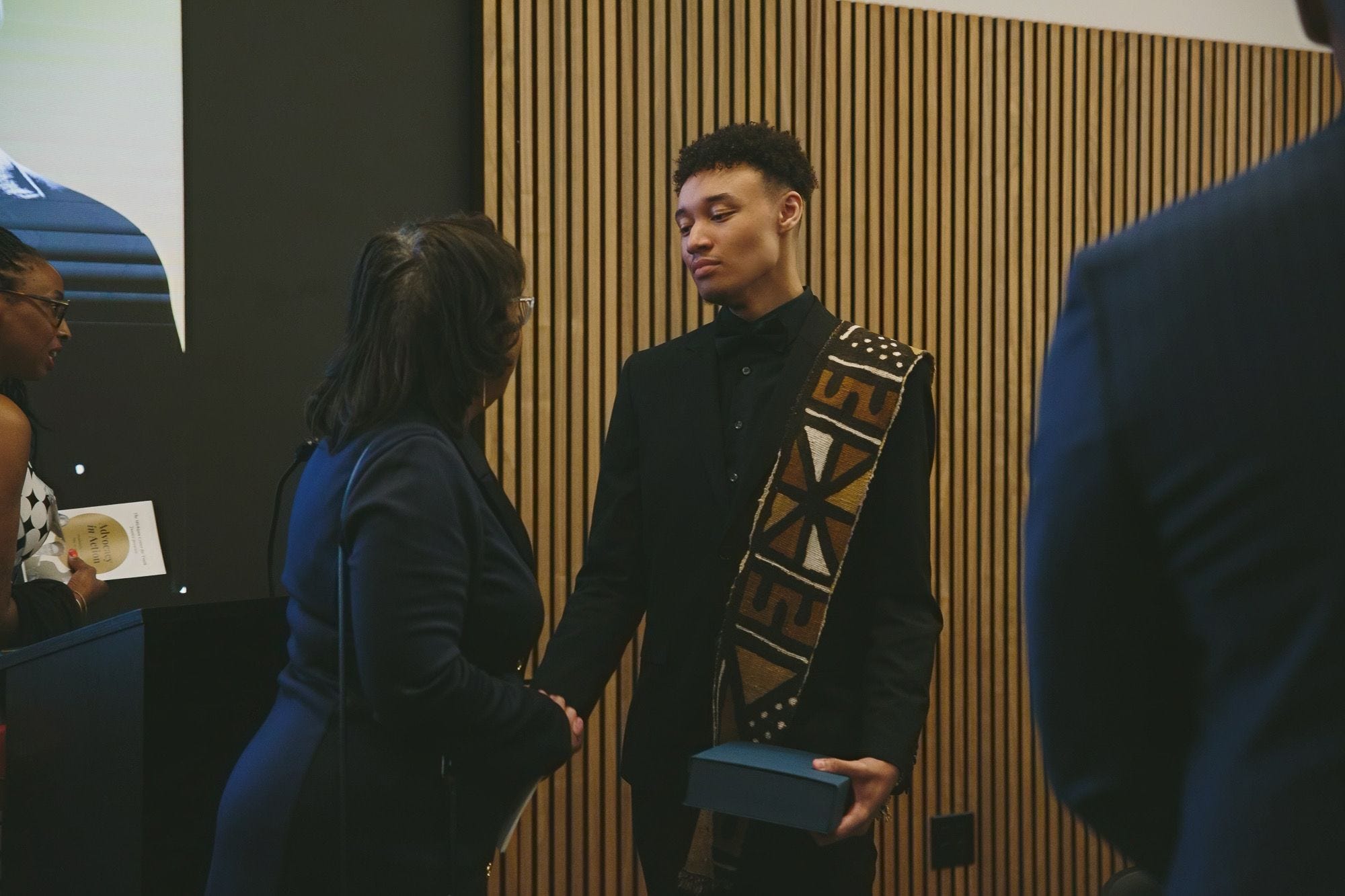 Cayden Brown stuns in an African-inspired mudcloth draped over his shoulder as he receives the ‘Youth Justice Advocate Award’