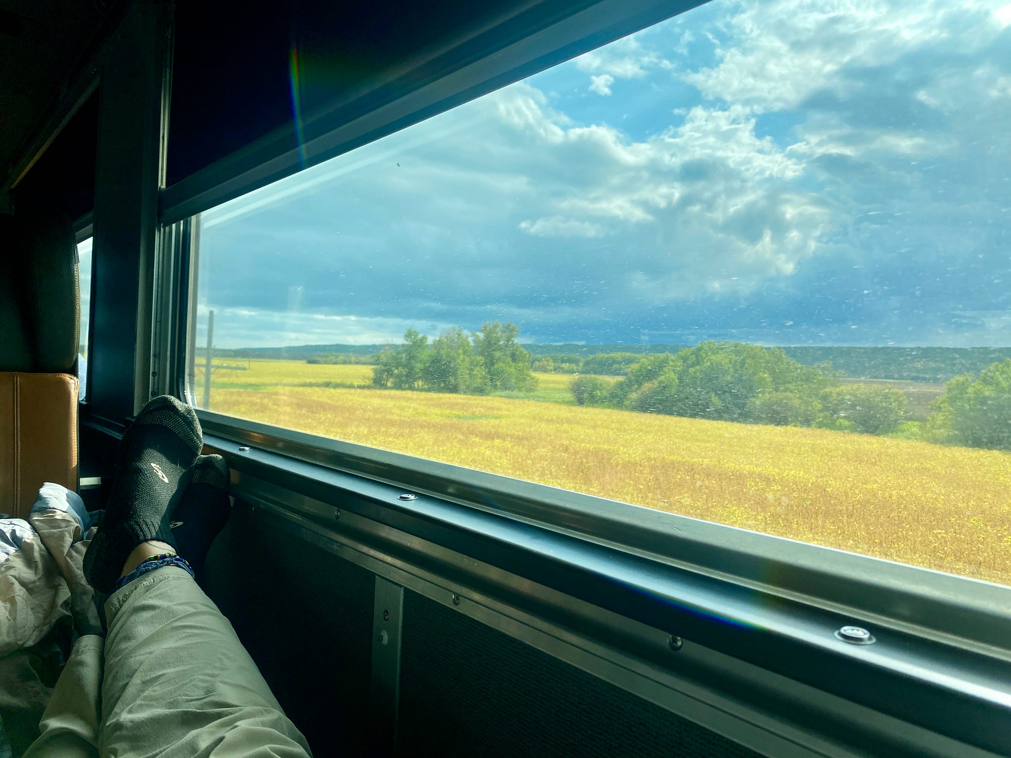 캐나다의 대초원 풍경을 바라보는 큰 창문 옆에 발을 올려놓고 있습니다.<BR>