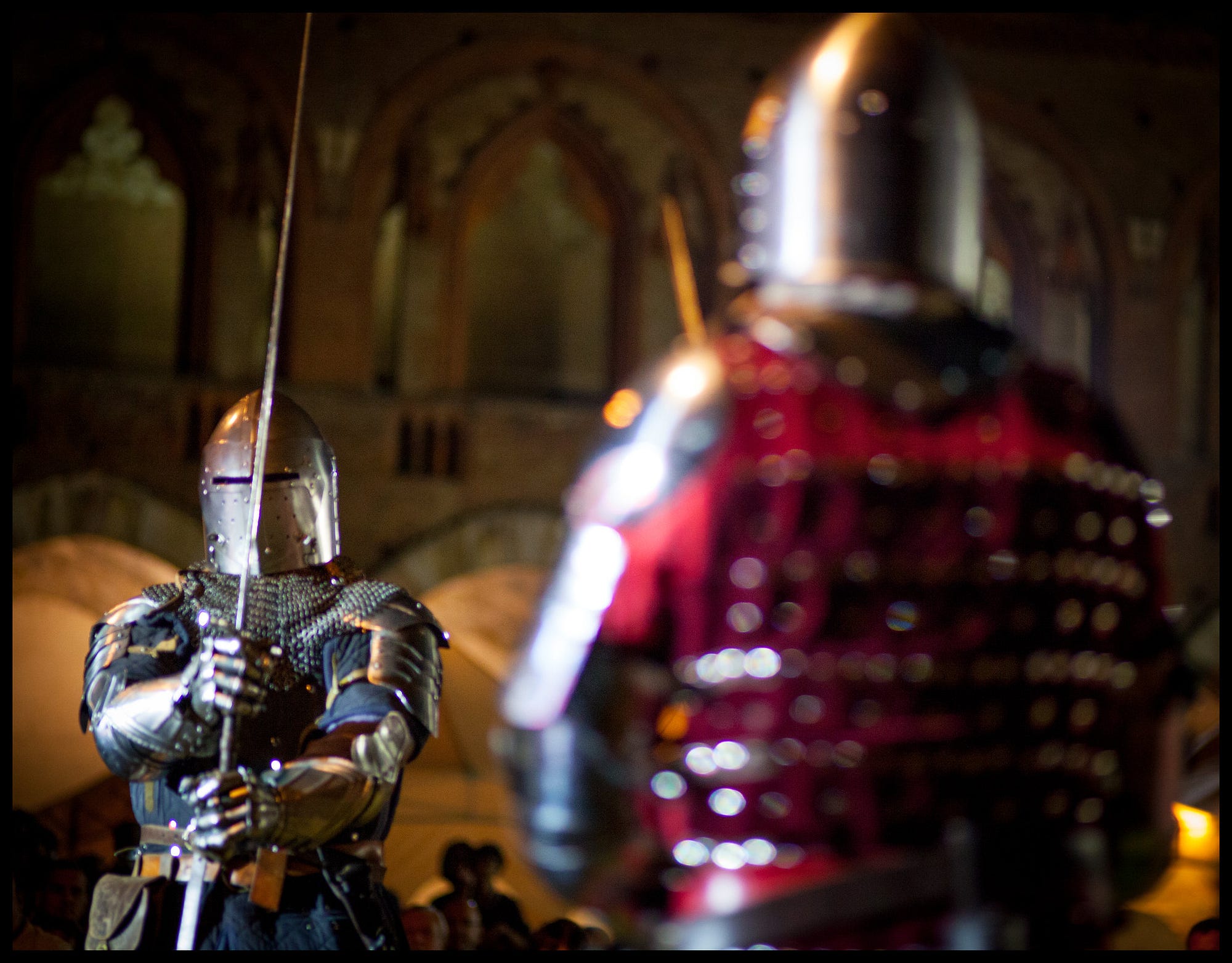 Two knights in armor fighting a duel with lances in a