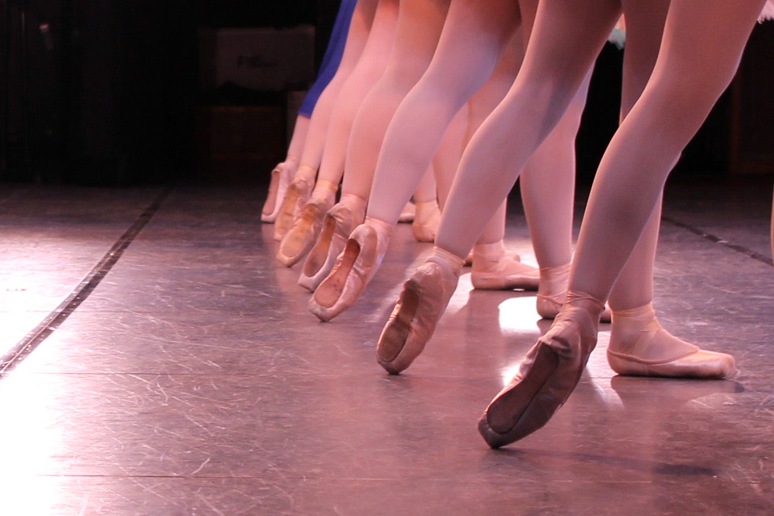 Boy and girl ballet dancers performing port de bras side stretches