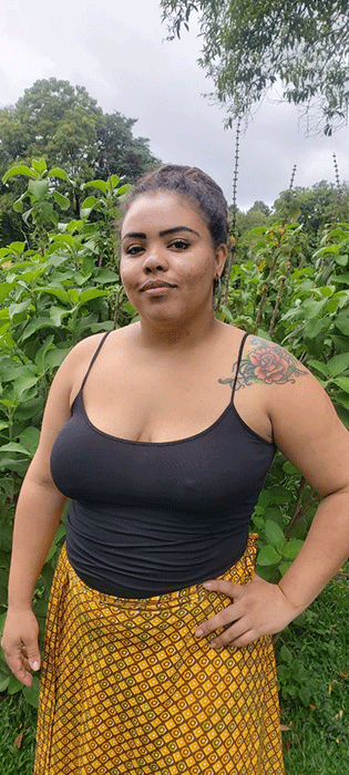 Uma mulher com longos cabelos negros e um top branco está em uma