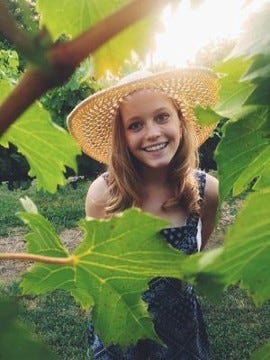 Headshot of Hannah Boylan through leaves.