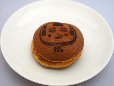 The kana け (ke) is used on this dorayaki, featuring the character Naruko-ttsan, to mean “Eat!” in the local dialect of Sendai, Japan. Free-to-use image at riscascape.net.