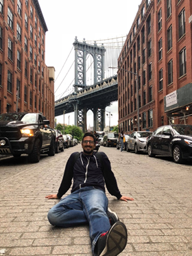 Man sitting on a brick street.