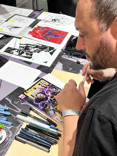 Luca Maresca customizing a cover for a fan at Prague Comic-Con 2025.
