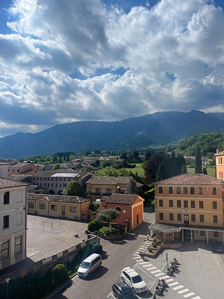 A scenic photo of an Italian village with a mountain in the background.