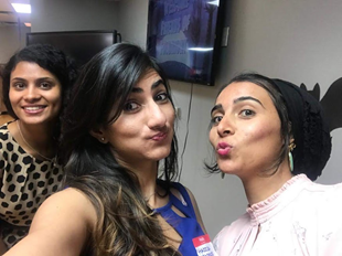 Woman taking a selfie with another person.