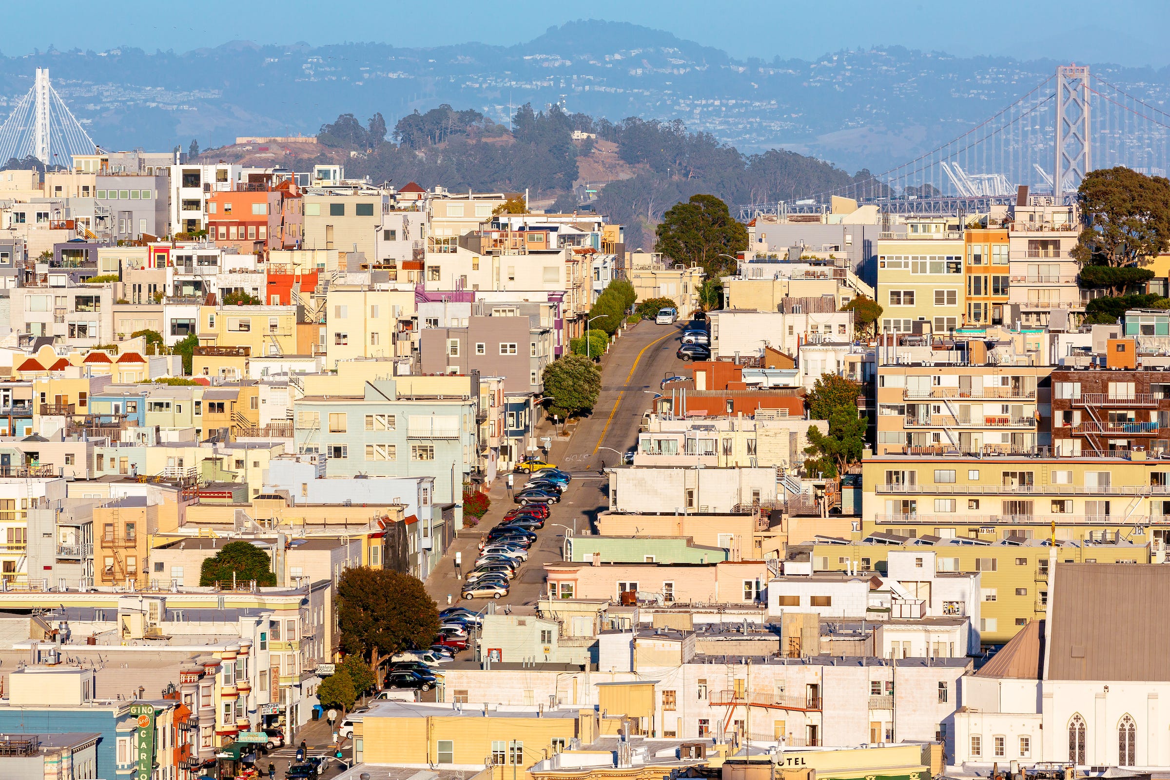 Aerial view of a street in North Beach looking toward Treasure Island and the two sides of the Bay Bridge.