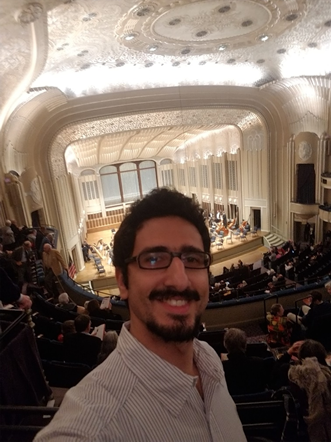 Man taking a selfie inside of a concert hall.