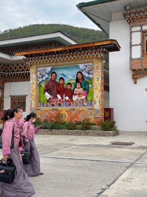 Traditional architecture and employees wearing local costumes greet visitors at Paro International Airport with a portrait of the Royal Family. Photo: Marybeth Bond