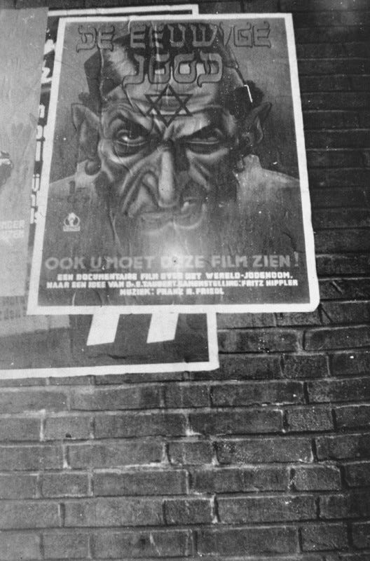 A poster advertising the antisemitic propaganda film “Der ewige Jude” (The Eternal Jew) hangs on the side of a Dutch building. Amsterdam, The Netherlands, 1942