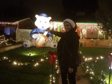 Woman posing next to Christmas decorations.