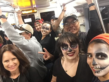 People on a metro wearing Halloween costumes.