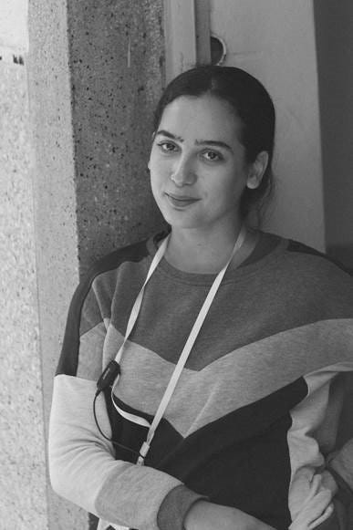 Woman posing next to a door, wearing black and white.